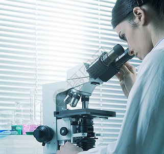使用显微镜的女性研究员工作服化学实验医护人员医生实验室科学家专注职业保健图片