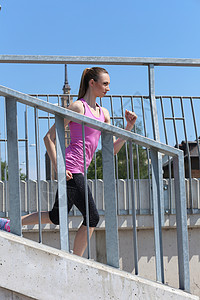 运动 有吸引力的女孩在街上奔跑阳光身体栏杆运动装街道城市楼梯活动头发绑腿图片