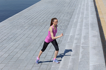 运动 有吸引力的女孩在街上奔跑太阳跑步青年街道绑腿活动阳光运动装发型公园图片
