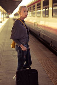 女士在火车站等着呢女孩民众平台时间旅行乘客城市火车游客金发女郎图片