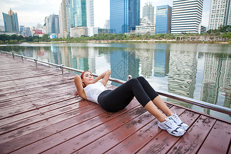 女性在户外锻炼微笑紧缩成人身体混血减肥海滩海洋蓝色仰卧起坐图片