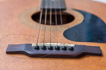 吉他和撕破弦声学木头乐器民间棕色指板艺术黑色字符串细绳图片