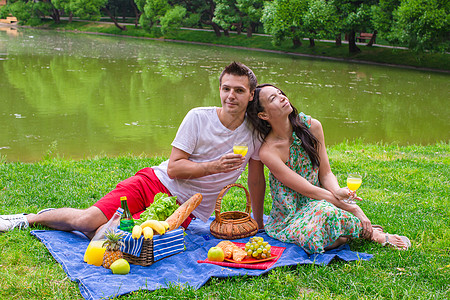 年轻快乐的情侣野餐和户外放松母亲时间幸福午餐家庭草地爸爸食物公园农村图片