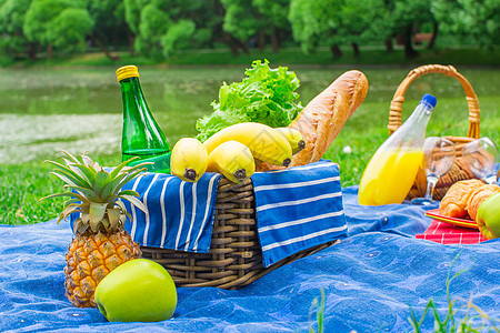 带葡萄和两杯白酒的篮子森林水果草地餐具面包奶制品公园蓝色菠萝桌布图片