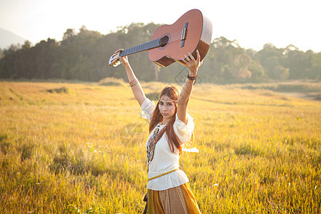 在金田的嬉皮妇女吉他幸福女性自由场地青少年乐器音乐歌手文化图片