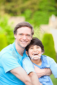 英俊父亲 在户外带着微笑的残疾儿子脑瘫家庭混血孩子男人混血儿保姆乐趣蓝色男生图片
