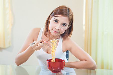 年轻女孩吃拉面面工作室女性筷子盘子文化微笑成人饮食午餐女士图片