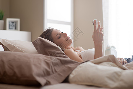 女人在卧室休息头发家居技术手机女性个性短信房子棕色沟通图片