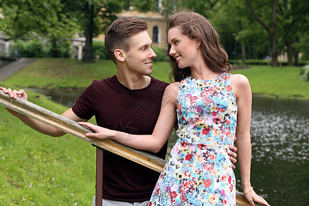 公园中漂亮的一对夫妇男人女朋友发型微笑女士栏杆男性裙子女性青年图片