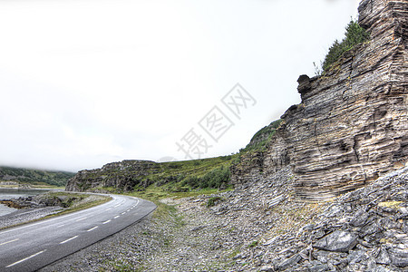 挪威北部的公路爬坡旅行土地风景天气天空苔原苔藓沥青岩石图片