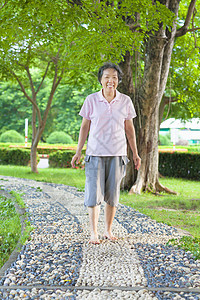 年长的亚洲老年妇女在石路上行走图片