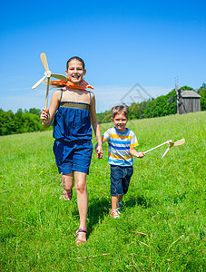 夏日的小孩有风车自由休息童年喜悦男生女性玩具木头姐姐跑步图片