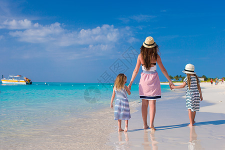 母亲和小女儿背对背视 享受暑假帽子乐趣海岸线海洋女孩幸福父母婴儿女性异国图片