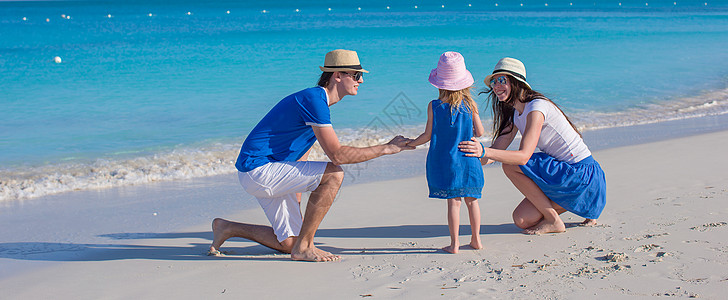 三口欢乐家庭 享受海滩度假情调热带母亲女孩异国女儿父母海岸线孩子女士图片