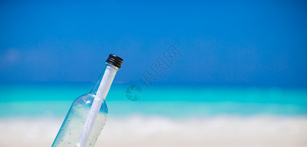 白沙中埋有口信的瓶子热带阳光软木邮件海岸线孤独旅行海景海岸文档图片