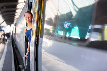 漂亮的年轻女人在火车站等她的火车游客女士旅游城际车辆车站速度木板女孩城市图片