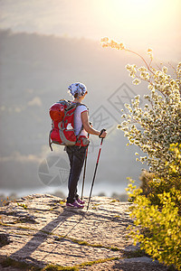 女性登山者站在悬崖上享受风景女孩自由女士远足冒险游客太阳背包岩石农村图片