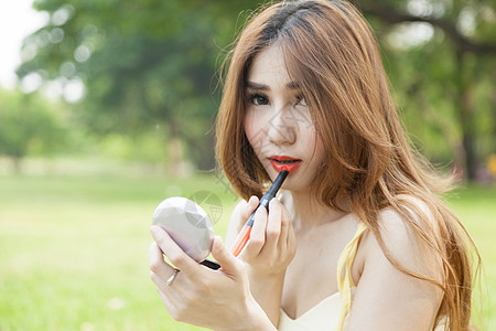 涂口红的妇女护理女性头发睫毛眼线笔皮肤成人眼睛睫毛膏镜子图片