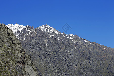 雪下和清蓝天空下的高加索山脉木头爬坡天蓝色旅游滑雪季节生长荒野滑冰天空图片