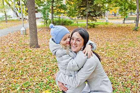 在秋天微笑的母亲和女儿女士黑发女孩女学生女性金发父母童年孩子白色背景图片