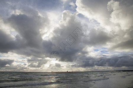 海滩视图波浪地平线日落海岸海浪码头灰色天空场景海岸线图片