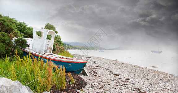 小船在石滩湖边的小沉船天空土地木头木板腐烂海滩船运石头日落海岸图片