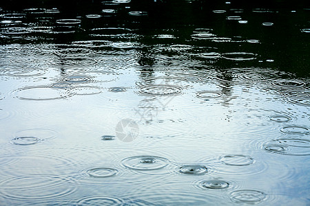 下雨天气雨滴反射蓝色水坑池塘天空飞溅波纹风暴涟漪图片