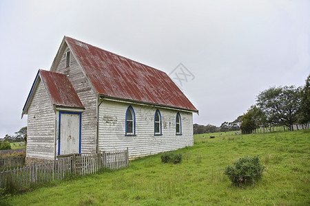 旧教会栅栏衬套旅行场地白色风化树木绿色房子图片