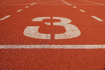 体育场的电动跑轨橡皮地面红色场地数字白色竞赛赛马场运动员竞争图片
