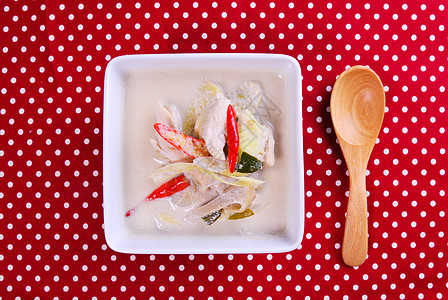 鸡肉加椰子牛奶汤中的鸡肉勺子牛奶白色香菜椰子香料红色辣椒草本植物午餐图片