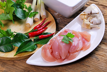 鸡肉加椰子牛奶汤中的鸡肉草本植物奶油柠檬椰子香菜辣椒牛奶香料勺子白色图片