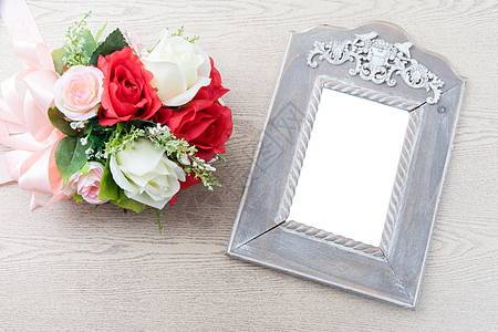 在玫瑰花束旁带白色空间的木边框背景图片