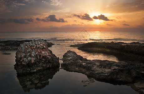 太阳用古老的废墟日落在海和洛基海岸上空史诗阳光支撑海浪地平线海滩岩石建筑学反射旅行图片