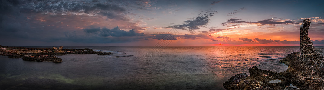 太阳用古老的废墟日落在海和洛基海岸上空石头海洋支撑海浪阳光建筑学地平线反射旅行场景图片