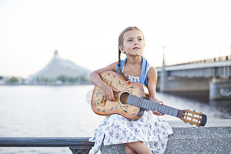 女孩在河堤边弹吉他图片
