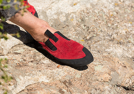 在岩石上紧贴红色橡皮攀岩鞋图片