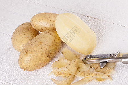 含有Peeler和Peeled皮肤的土豆金属营养淀粉农业饮食食物厨房蔬菜块茎刀刃图片
