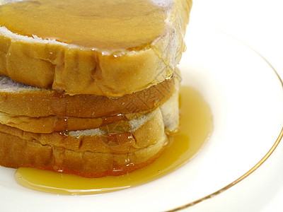 面包和蜂蜜在盘子上 孤立在白色上棕色小吃饮食早餐食物硬皮糕点脆皮美食黄油图片