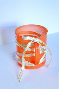 橙色塑料杯 用丝带遮盖图片