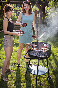 两个漂亮女孩在烤架上做饭烹饪女孩野餐香肠黑色女性花园烤串饮食牛肉图片