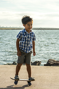 一个男孩 一个男孩的董事会滑板婴儿孩子们孩子男生海水公园海洋运动岛民图片