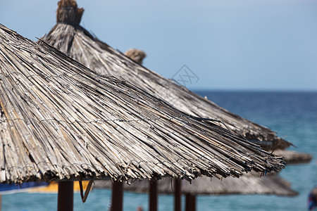 海滩伞稻草蓝色沙滩天空阳伞遮阳棚气候芦苇热带木头图片