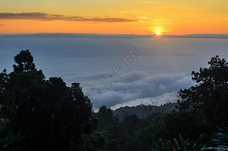 白云上方的日出多彩高地天空蓝色橙子阳光风景景点顶峰薄雾天际图片