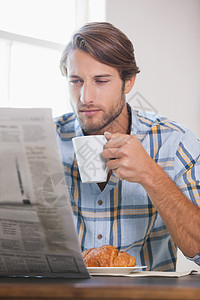 喝咖啡和阅读报纸的英俊男子图片