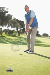 高尔夫球在绿色上投球时间闲暇运动专注享受晴天活动阳光边缘爱好图片