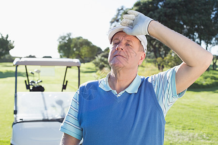快乐的高尔夫球手在后面看高尔夫鼓背着高尔夫虫的相机图片