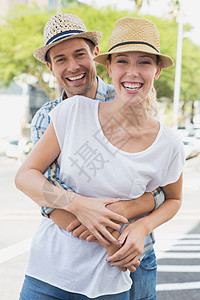 年轻嬉皮夫妇在相机上拥抱和微笑男人城市生活草帽活动头发闲暇浅色成人快乐女性图片