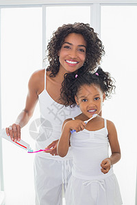 每日一起漂亮的母亲和女儿一起刷牙的漂亮妈妈闲暇童年牙科女士房子浴室口腔睡衣卫生牙刷背景