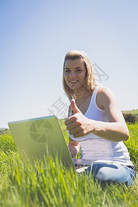 金发美女坐在草地上 用她的笔记本电脑微笑着女士场地农村头发环境双手手势快乐浅色背心图片