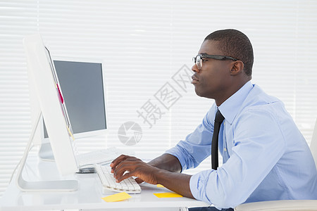 坐在办公桌办公的有重点的商务人士男人衬衫电脑旋转技术机构人士电脑显示器键盘工作图片